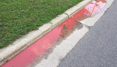 red liquid running along curb in street