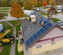Solar panels being installed by crane on the campground shower house roof.
