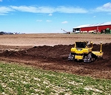 bulldozer moving soil on agricultural field