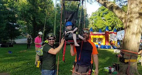 Staff helping with an adaptive climbing event